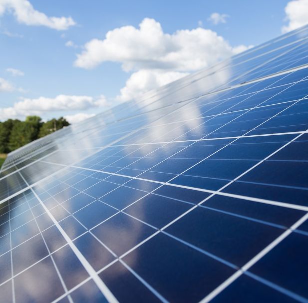 Close-up of solar panels reflecting the sky, symbolising clean energy and a commitment to Net Zero emissions. 